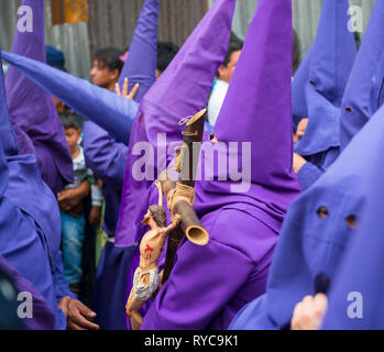 La procession des cucuruchos à Quito pendant Pâques avec un homme portant une statue de Jésus-Christ sur la croix, en Équateur. Banque D'Images