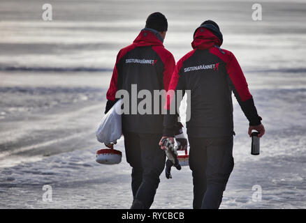 Deux travailleurs Sigtunarannet marque en portant une tenue metal pierres de curling à Sigtunarannet 2019, le lac Malaren, Sigtuna, Suède, Scandinavie Banque D'Images