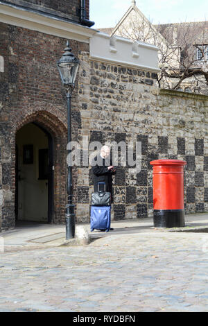 Un membre du clergé textos en Charterhouse Square, London, UK Banque D'Images