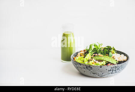 Dîner ou déjeuner sain à la maison. Superbowl Vegan ou Bouddha bol d'hummus, légumes, salade, haricots, couscous et d'avocat et de smoothie vert Banque D'Images