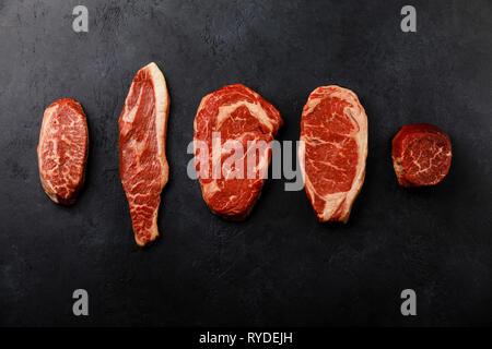 Variété de matières premier Black Angus Steak viande lame supérieure, haut de surlonge cap, le faux-filet, filet, filet mignon sur fond sombre Banque D'Images