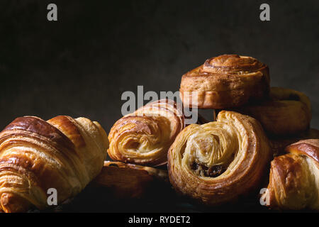 Variété de pâte feuilletée faite maison à la cannelle brioches et croissants. La vie encore sombre. Close up Banque D'Images
