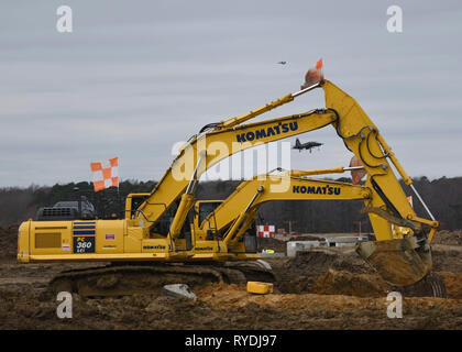 Les travailleurs de la construction d'Aspen déplacer un segment de tuyau de ciment sur le chantier de construction à l'aérodrome Joint Base Langley-Eustis, Virginie, le 4 mars 2019. Le 633e Escadron de génie civil a commencé la construction de la zone claire du projet de drainage pour installer de nouveaux systèmes de drainage qui va débarrasser l'aérodrome de l'eau plus efficacement. (U.S. Air Force photo par un membre de la 1re classe Monica Roybal) Banque D'Images