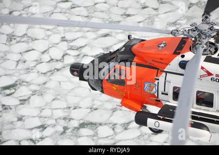 Un U.S. Coast Guard Air Station Traverse City hélicoptère Jayhawk MH-60 transits de l'équipage de l'autre côté de la baie Grand Traverse congelé, Traverse City, Michigan, le 27 février, 2018. Le MH-60 équipage effectuait le froid et la formation de sauvetage sur glace. (U.S. Photo de la Garde côtière par Seaman Brendan Stainfield) Banque D'Images