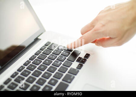 La technologie s'applique aussi aux relations affectives : a woman's hand est sur le point d'appuyer sur une touche sur un clavier d'ordinateur portable avec un coeur gravé Banque D'Images