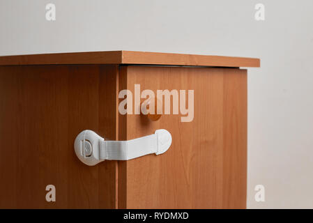 Table de chevet bois avec verrou d'armoire d'épreuvage de bébé à la maison Banque D'Images