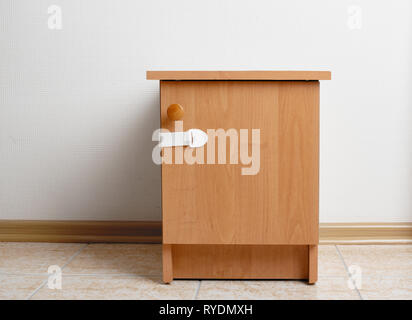 Table de chevet bois avec verrou d'armoire d'épreuvage de bébé à la maison Banque D'Images