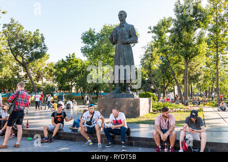 Kiev, Ukraine - le 10 août 2018 : Journée ensoleillée à Kiev avec Kontraktova Square Park et les gens assis par Skovoroda statue monument à l'extérieur Banque D'Images