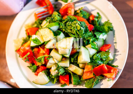 Libre de télévision haut de concombres vert frais sur la plaque avec des couleurs vibrantes et tomates Salade de poivrons rouges avec du persil haché et de roquette à homegr Banque D'Images