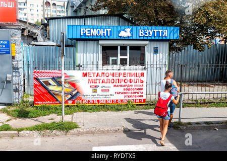 Kiev, Ukraine - le 21 août 2018 : Rue avec publicité pour la réparation de chaussures store shop et personnes marchant par sur la chaussée dans l'Oblast de Volhynie Banque D'Images