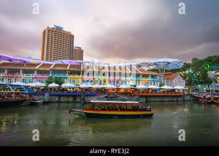 Coucher Soleil nuages roses colorées sur Clarke Quay, où les touristes ride bateaux le long de la rivière Singapour. Banque D'Images