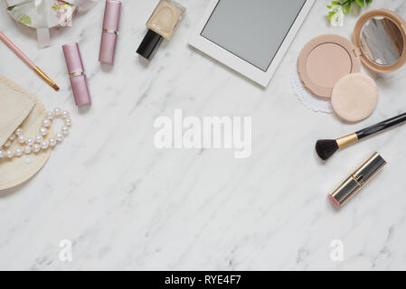 Espace Féminin sur table bureau avec smartphone, rouge à lèvres, collier de perle, la poudre compacte, libre et vernis à ongles sur la pierre de marbre backgroun Banque D'Images