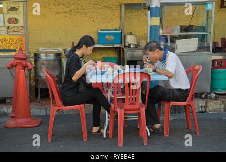 Les gens de manger et de boire du thé et du café à des stands de nourriture dans les rues de George Town, Penang, Malaisie,Asia Banque D'Images