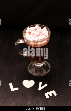 Boisson chaude dans une tasse en verre avec guimauves rose Banque D'Images