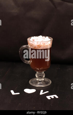 Boisson chaude dans une tasse en verre avec guimauves rose Banque D'Images