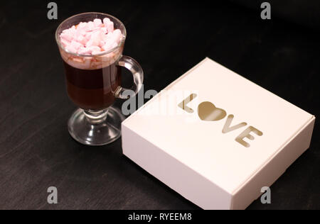 Boisson chaude dans une tasse en verre avec guimauves rose Banque D'Images