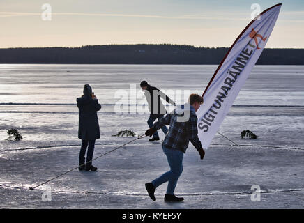 Femme tirant de corde pour faire tourner le cercle géant coupé en glace du lac Malaren Vikingarannet Sigtunarannet au cours de 2019, Sigtuna, Suède, Scandinavie Banque D'Images