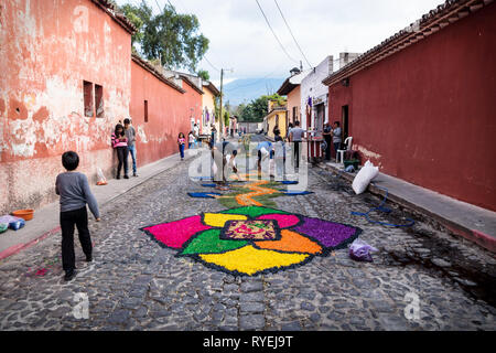 Antigua, Guatemala - 23 mars 2018 : Les gens de faire alfombre tapis de fleurs colorées sur les rues pavées Banque D'Images