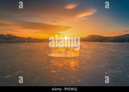 Close-up de briser la glace sur l'eau gelée au coucher du soleil dans le lac Baïkal, Sibérie, Russie. Banque D'Images