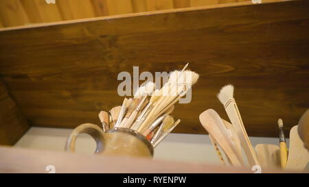 L'intérieur de pinceaux la tasse sur le plateau utilisé pour la peinture toile Banque D'Images