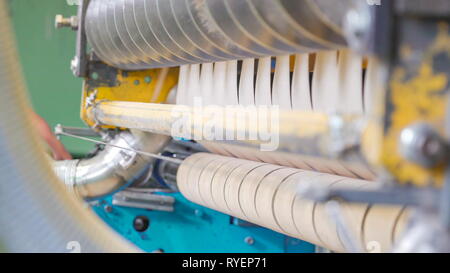 Une machine à l'intérieur de l'usine de papier dans l'usine avec l'Estonie Zawj Moussa petite bande de roulement et un tuyau d'exécution Banque D'Images