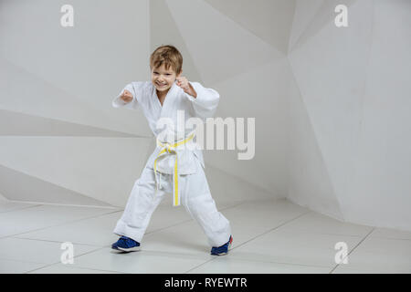 Happy Young boy wearing kimono et debout dans l'attaque ou la défense de l'intérieur de position Banque D'Images