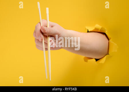 Hand holding chopsticks Banque D'Images