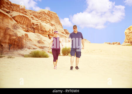 Multi Ethnic couple walking heureusement après une aventure dans le désert de Wadi Rum. Banque D'Images