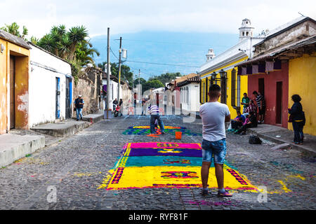 Antigua, Guatemala - 23 mars 2018 : les habitants travaillant sur des tapis de fleurs colorées Alfombre sur les rues pavées Banque D'Images