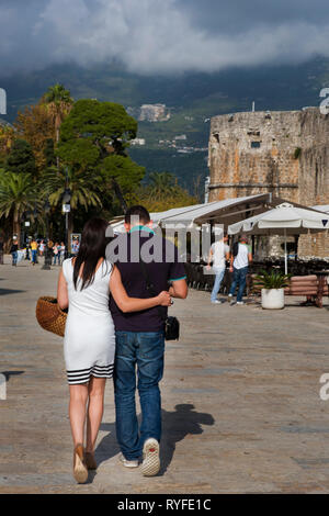 Couple en train de marcher sur la promenade près de l'extérieur de la vieille ville fortifiée, Budva, Monténégro Banque D'Images