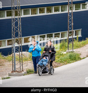 Adolescente poussant une poussette de bébé avec son ami, Qaqortoq, Sud du Groenland Banque D'Images