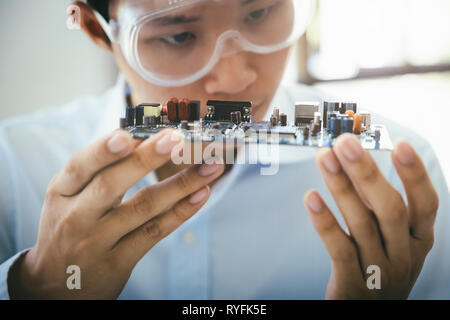 Technicien vérifie l'appareil électronique. Circuit imprimé pour le robot. Banque D'Images