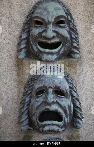 Statue / monument de masques de théâtre sur une pierre tombale dans le Cimitero Monumentale di Milano - Cimetière Monumental - Milan Italie Banque D'Images