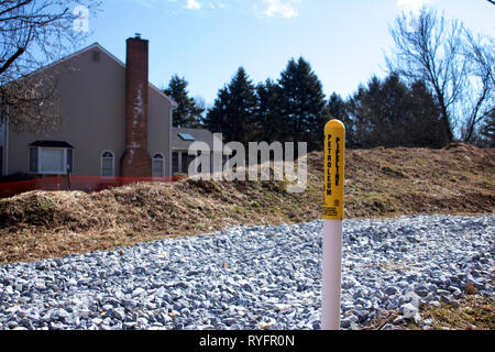 East Goshen, PA , USA - Mars 13, 2019 : Un marqueur d'avertissement simple se trouve à 100m d'une maison à côté du Mariner East II la construction du pipe-line site. Banque D'Images