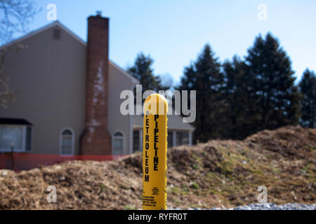 East Goshen, PA , USA - Mars 13, 2019 : Un marqueur d'avertissement simple se trouve à 100m d'une maison à côté du Mariner East II la construction du pipe-line site. Banque D'Images