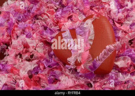 Saint Valentin coeur rouge attaché avec du ruban rose sur fond de fil ruban rose et pourpre Banque D'Images