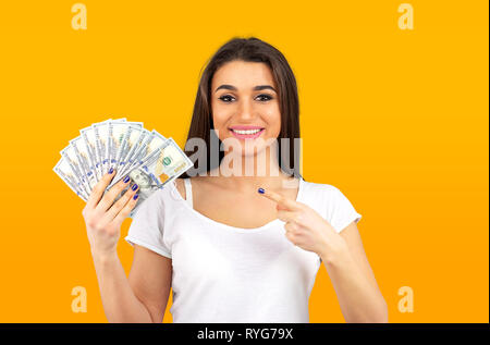 Portrait d'une femme riche sentiment super heureuse détention fan de dollar argent isolé sur fond jaune Banque D'Images