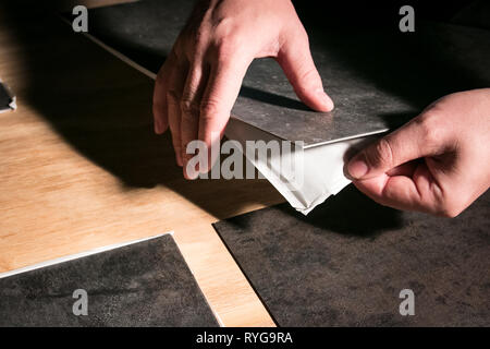 Retrait de l'appui de peler et coller les carreaux de vinyle. Banque D'Images