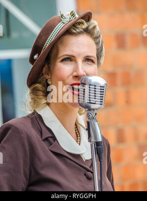 Woodhall Spa 1940 Festival - femme en robe traditionnelle des années 40, chantant Banque D'Images