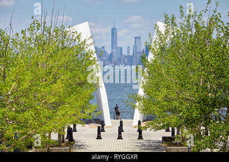 New York, USA - 29 juin 2018 : l'homme se tient entre les cartes postales, Staten Island le 11 septembre avec Memorial Manhattan à distance. Banque D'Images