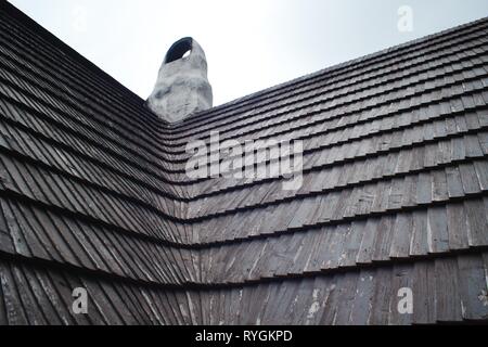 Vieux toit en bardeaux de bois. L'architecture traditionnelle en Europe. La cheminée fait main. Banque D'Images