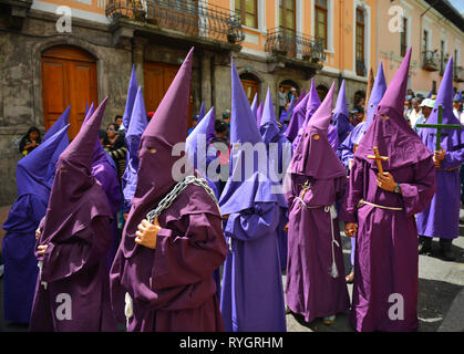 Procession catholique de personnes pénitentes cucuruchos avec des vêtements violets à Quito pendant Pâques le vendredi Saint, Équateur. Banque D'Images