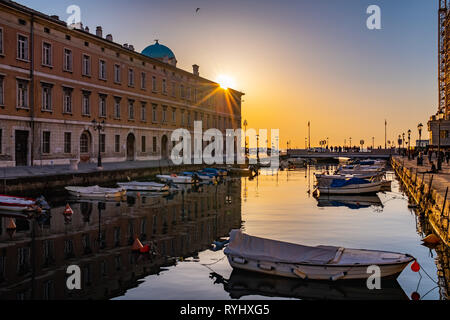 Vue depuis le Grand Canal avec quelques petits bateaux au coucher du soleil sur l'adriatique sur l'océan en soirée Triest, Italie Banque D'Images