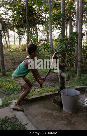 Le BANGLADESH Boy de minorités tribales Garo obtenir de l'eau d'une pompe à main, Haluaghat, Mymensingh région photo par Sean Sprague Banque D'Images