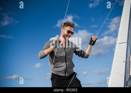 L'Homme à lunettes attrayants sur le yacht. Fermer portrait of a happy face, fou rire yachstman sportif attrayant. Close up portrait of outdoor Banque D'Images