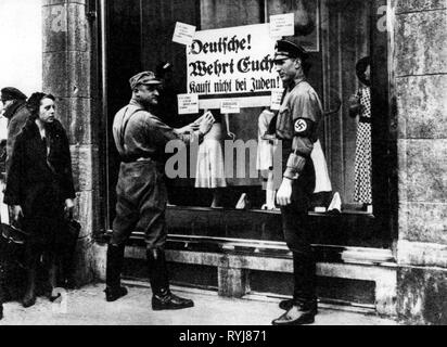 Le nazisme / National-socialisme, la persécution des Juifs, le boycott des magasins juifs, bataillon de tempête et l'homme SS man sticking boycotter poster sur vitrine, le "Deutsche ! Wehrt Euch ! Kauft nicht bei Juden !' probablement Berlin, Allemagne, 1.4.1933, Additional-Rights Clearance-Info-Not-Available- Banque D'Images