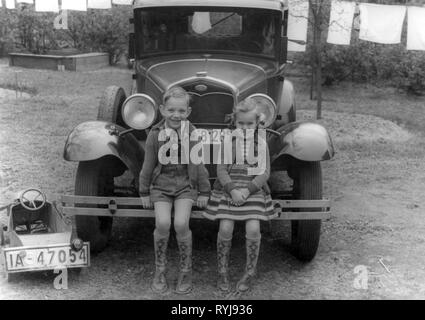 Les gens, les enfants, frères et sœurs - / groupe mixte, garçon et fille assise sur le pare-choc d'une voiture, Berlin, 1930, Additional-Rights Clearance-Info-Not-Available- Banque D'Images