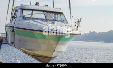 Un examen plus attentif de l'hors-bord blanc sur le port de Stockholm La Suède étant élevé par une grue pour camion Banque D'Images