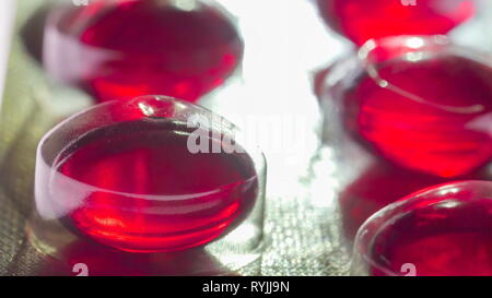 Couvercle en plastique sur les capsules rouges sur une macro shot à partir de la boîte de médicament Banque D'Images