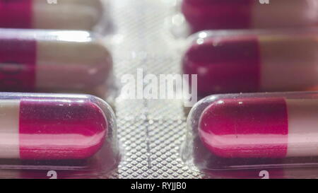 Un pack de la medicine capsules sur une macro shot avec les capsules rouge et blanc sur le pack Banque D'Images